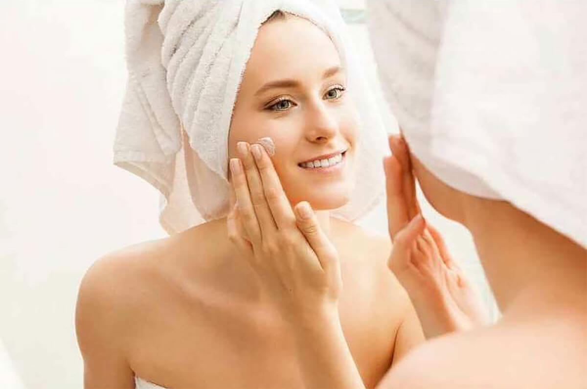 female putting skincare on cheek