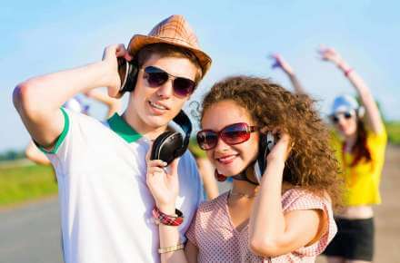 man and woman listening to headphones wearing sunglasses