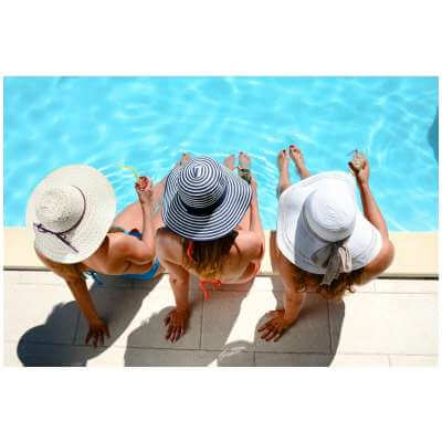 three woman sitting pool side