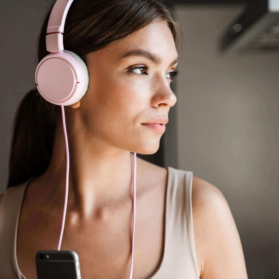 female listening to pink headphones