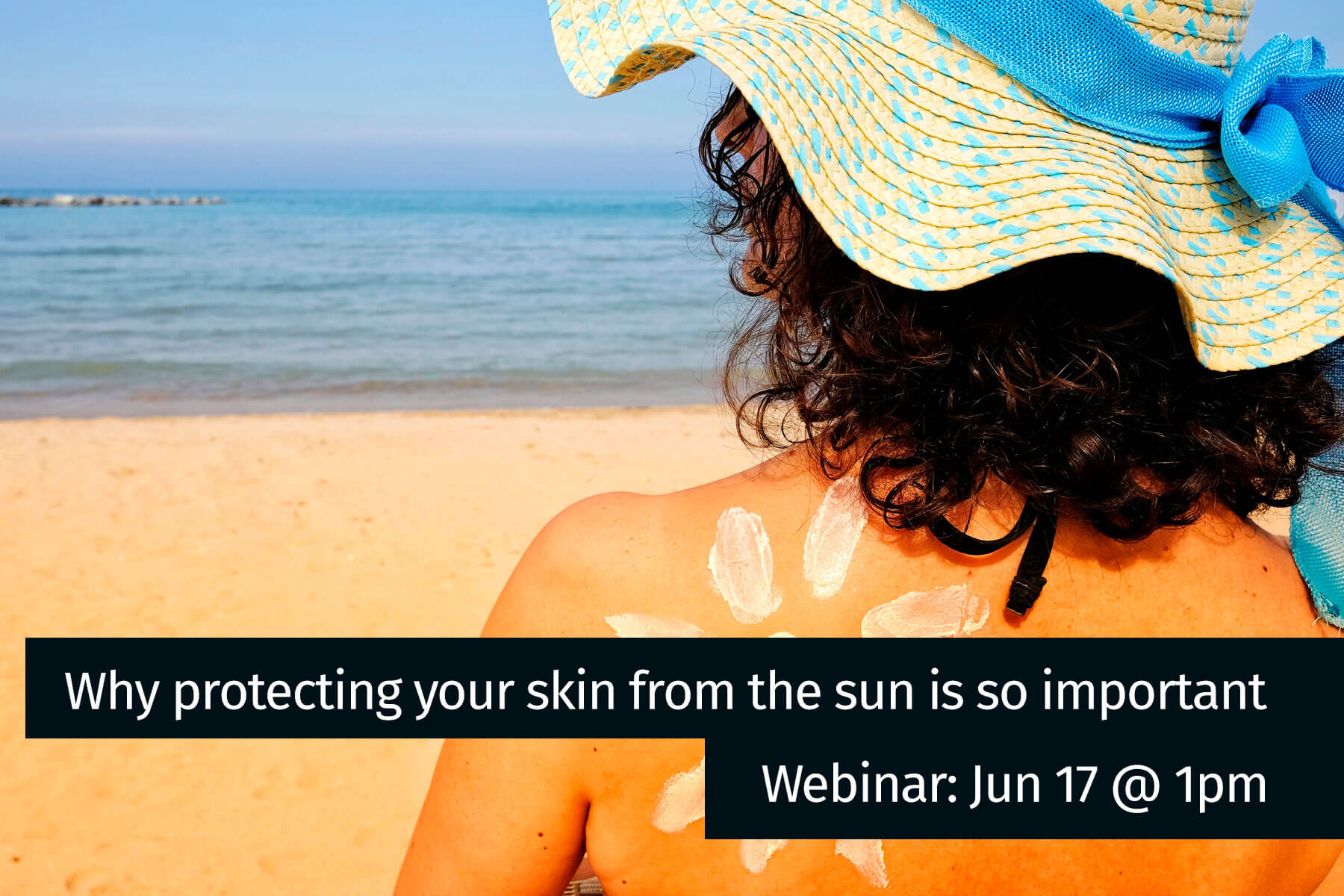 Why protecting your skin from the sun is so important webinar image - woman on beach with sun lotion in flower on her shoulder