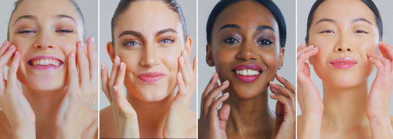 four female faces with hands near faces