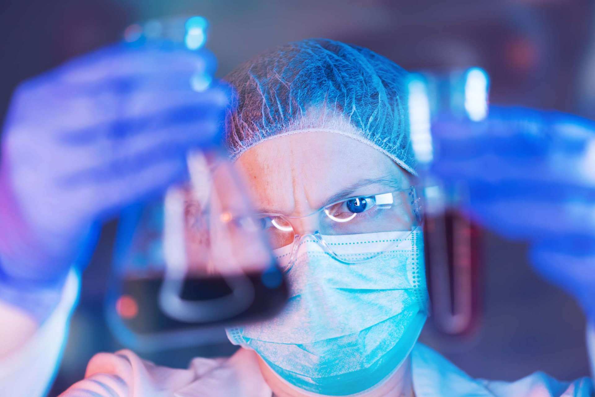 Scientist working with chemicals in laboratory, female researcher analyzing liquid reagent in lab glassware