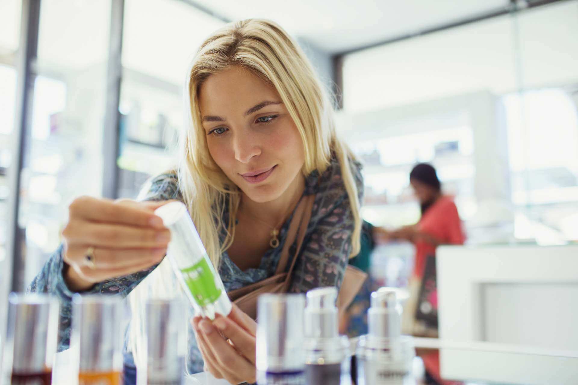 blonde female shopper examining skin care in store