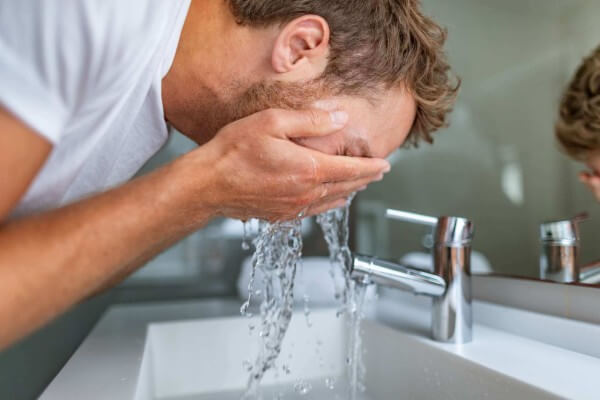 man washing his face