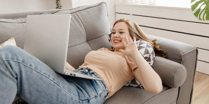 smiling woman on couch during video chat