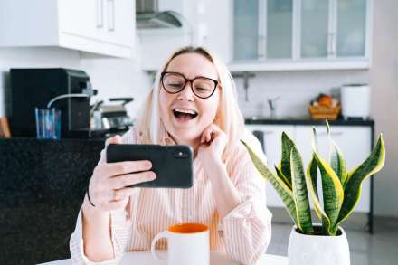 happy-girl-sitting-at-home-kitchen-and-holding-videocall-young-woman-using-smartphone-for-video-call_t20_9km87Y