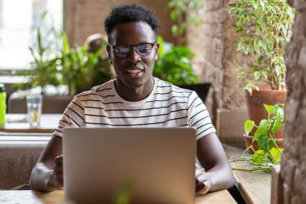 millennial-black-man-student-in-striped-t-shirt-wear-glasses-watching-educational-webinar-on-laptop_t20_7yK1nB