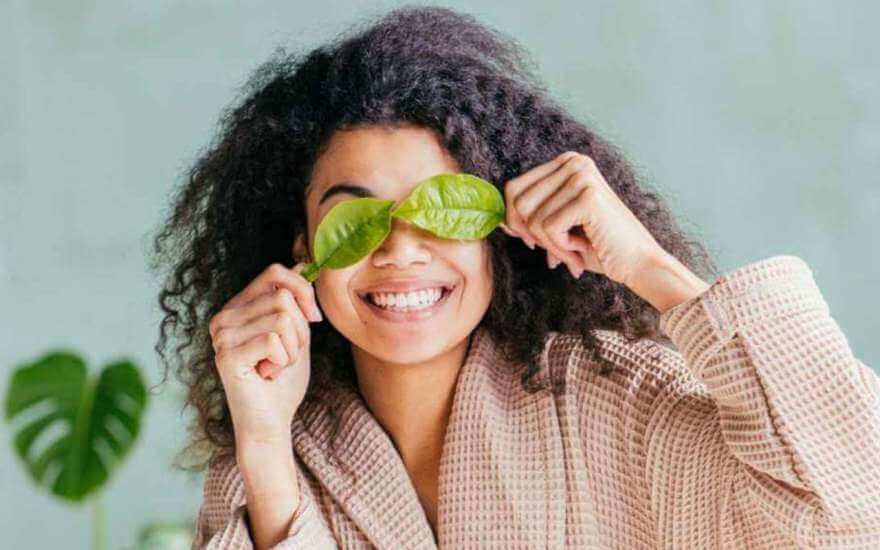 Vegan-ish girl in robe covering eyes with leaves