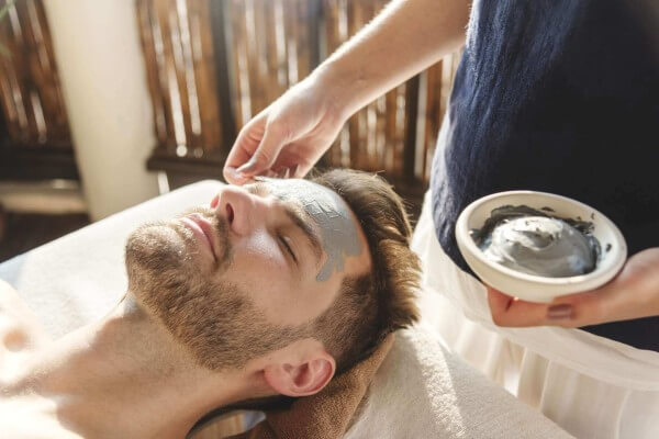 man getting a mud mask facial