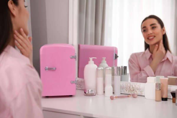 female using skincare products with skincare fridge