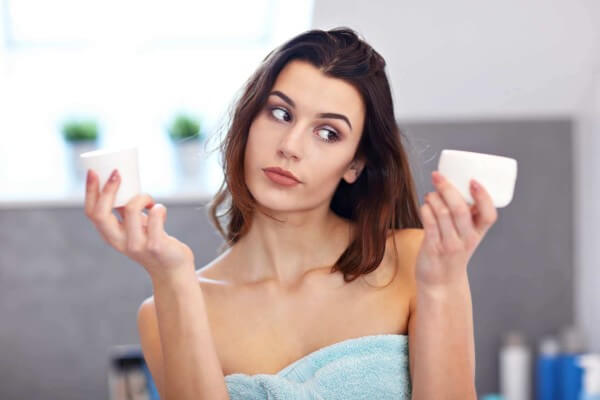 young woman standing in bathroom and applying face 2022 05 20 06 31 32 utc