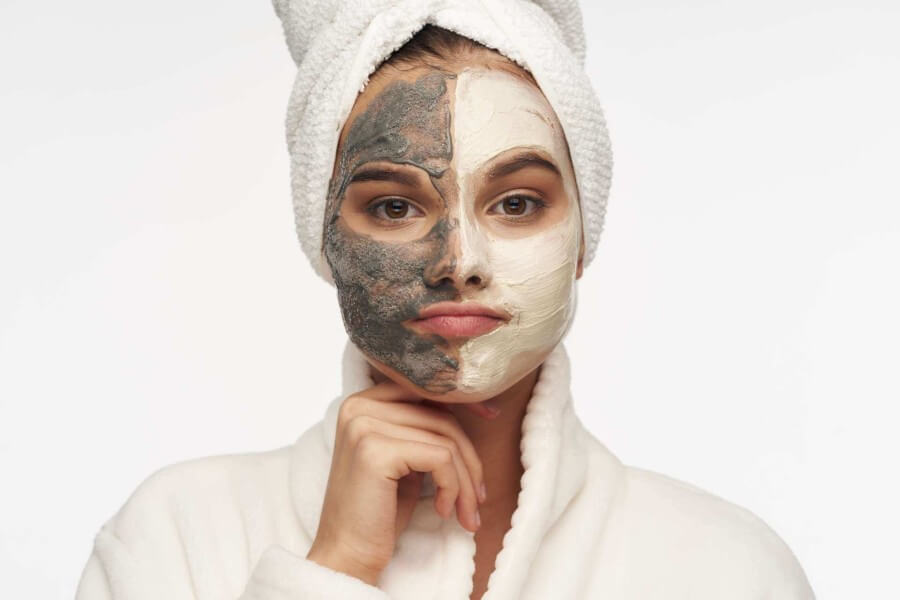 Female wearing two different clay masks - as338958038