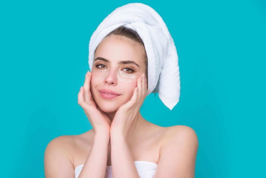 beautiful female with towel on wet hair wearing collagen fiber eye pads as568027848