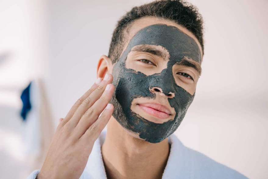 confident young man applying face mask with hand a 2022 12 30 02 18 12 utc