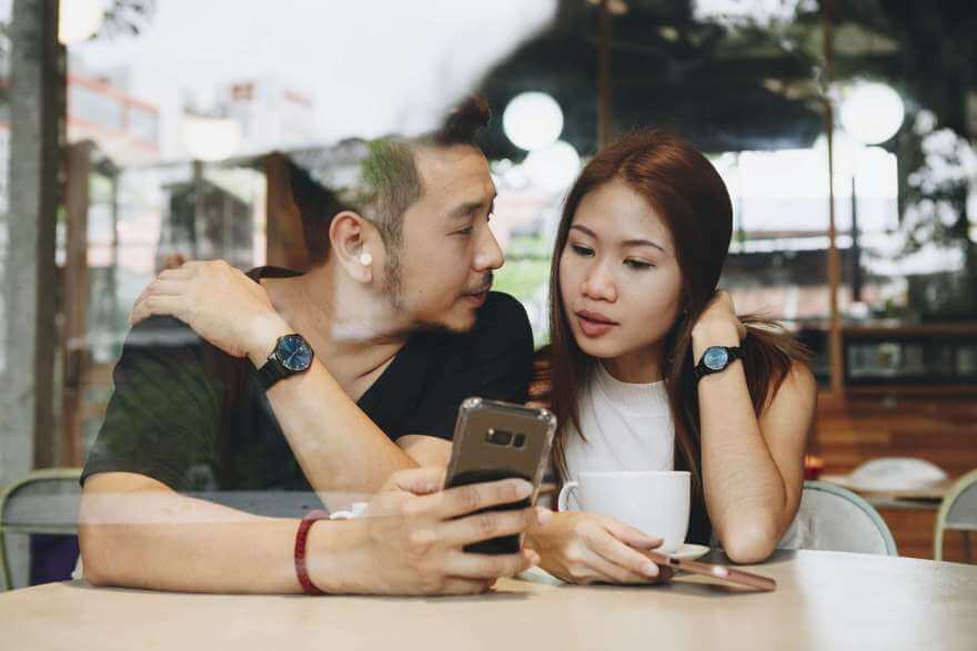 couple using a phone at a cafe 2022 12 16 00 54 19 utc