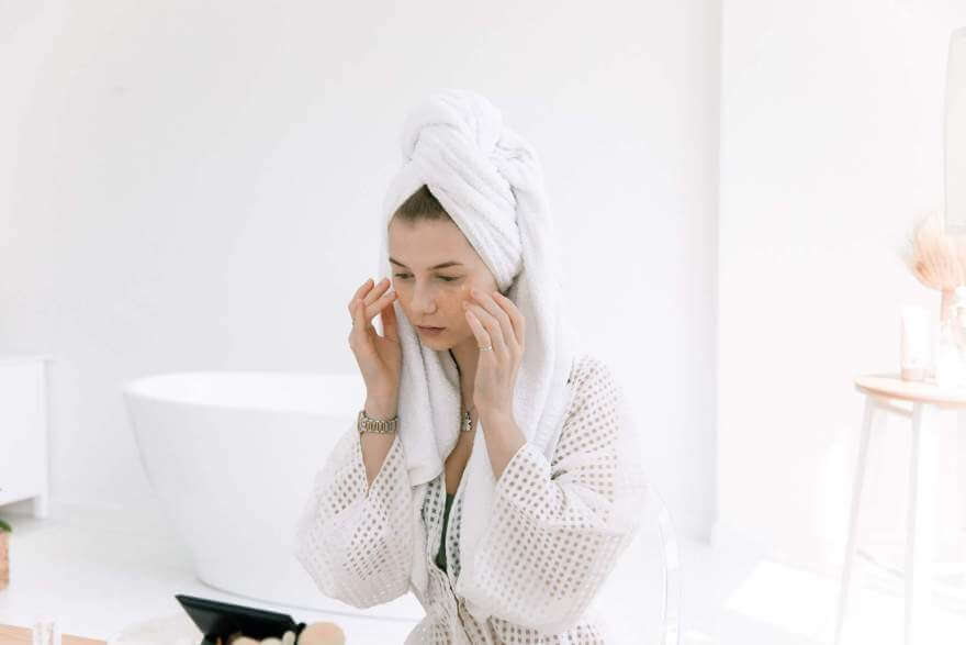 female in bathroom with towel on head touching her face pexels ekaterina bolovtsova 4672662