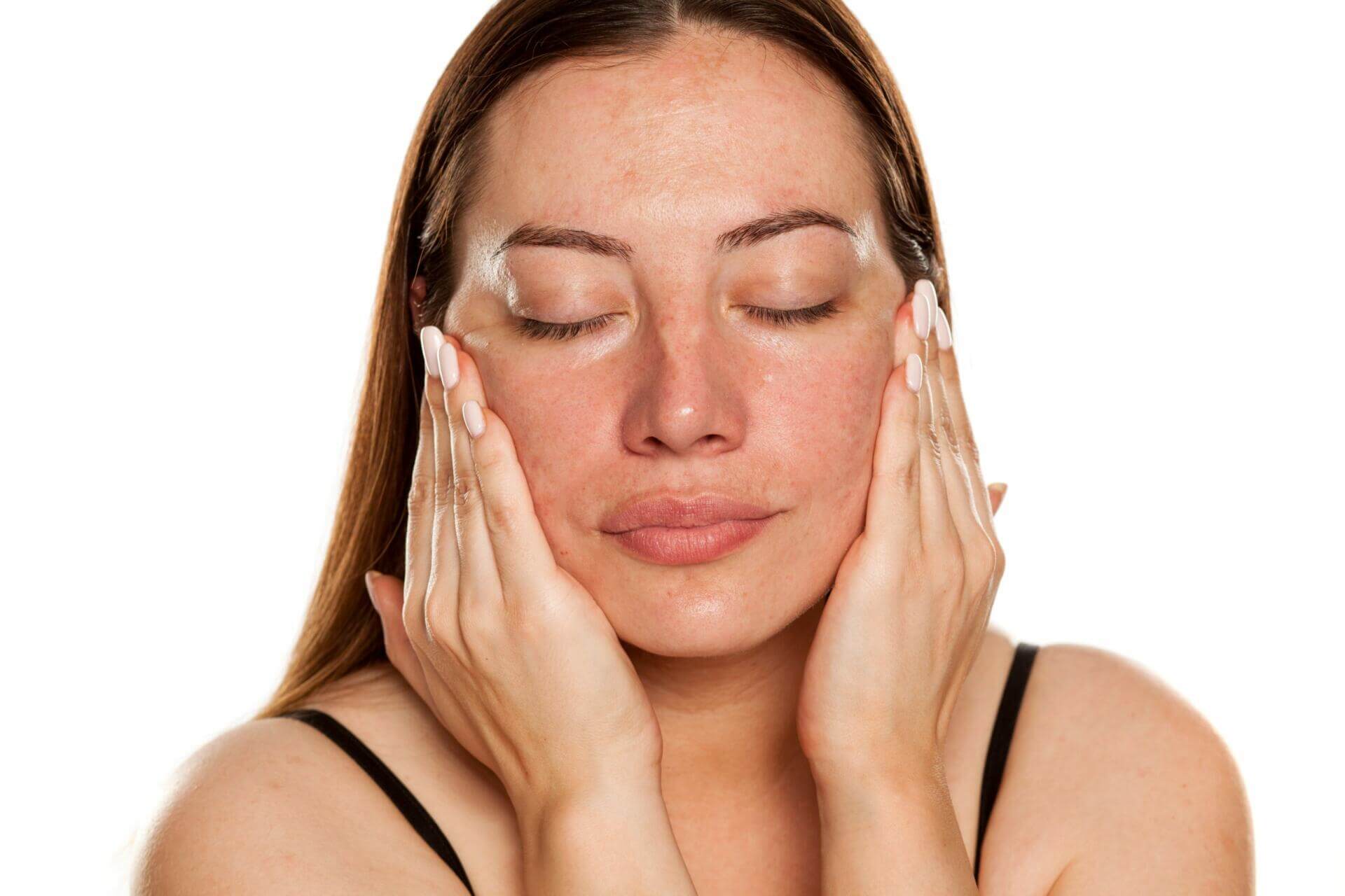 beautiful middle aged woman applying moisturizer on her face on