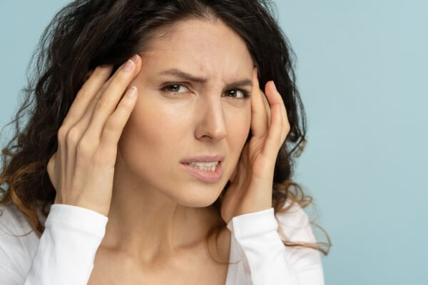 worried woman has signs of aging skin, checking crows feet troubled with wrinkles on face, isolated