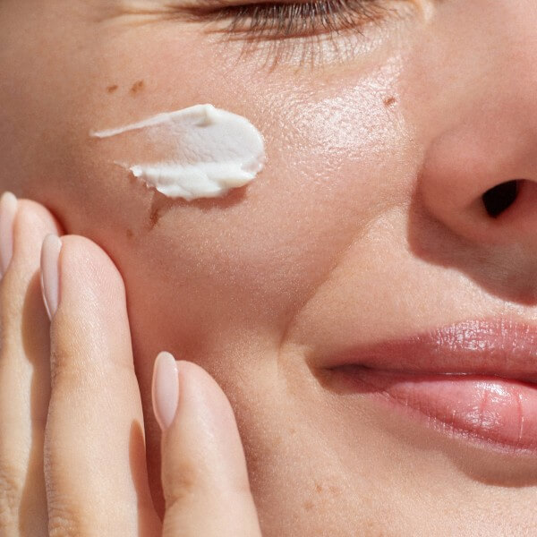 hydration. cream smear. beuaty close up portrait of young woman