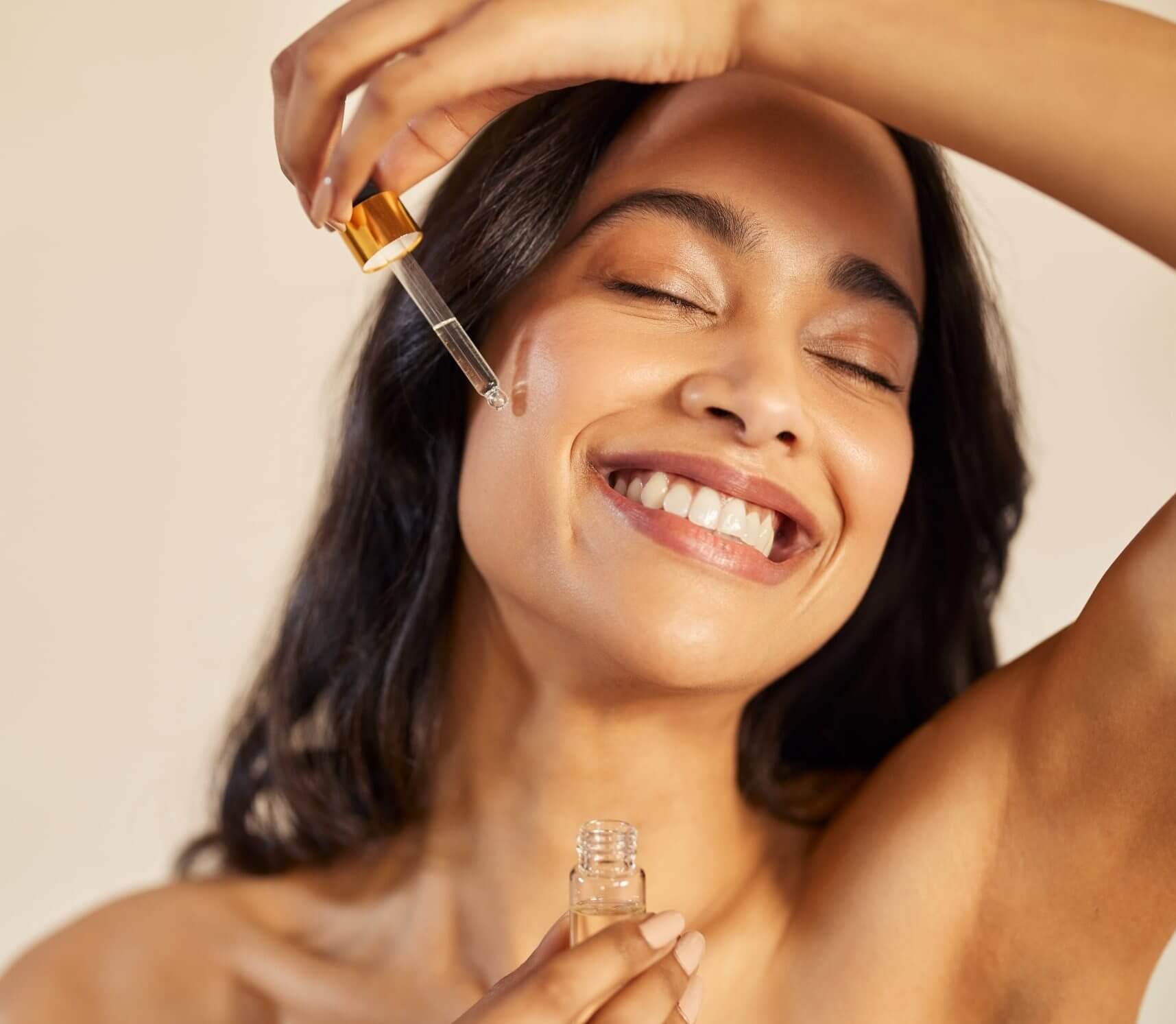 beauty latin woman applying serum on face