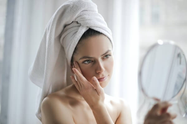 Woman with towel looking in mirror