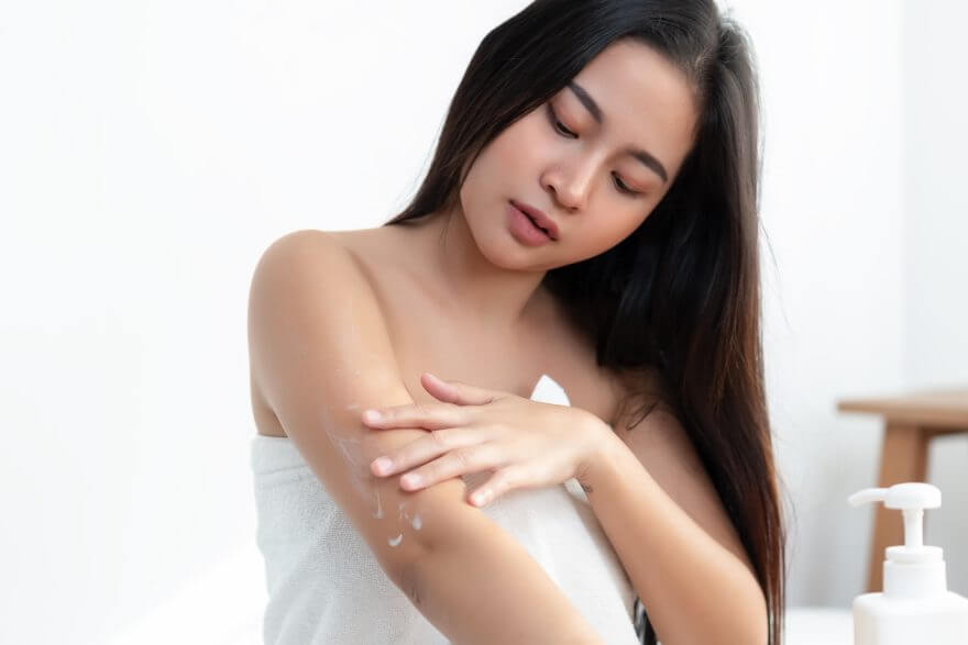 body skincare treatment concept. woman applying skin cream arm a