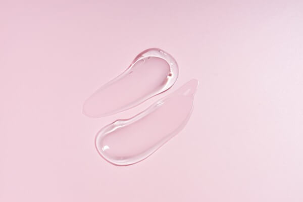 glycerin gel texture. transparent serum smudges on pink background. liquid gel moisturizer with bubbles macro