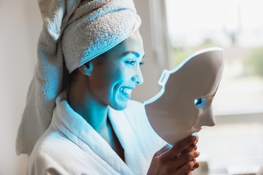 woman getting a led light facial mask treatment at the beauty salon