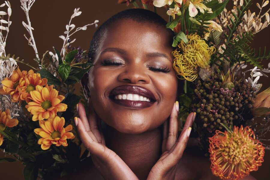 skincare cosmetics and protea with the face of a woman in center