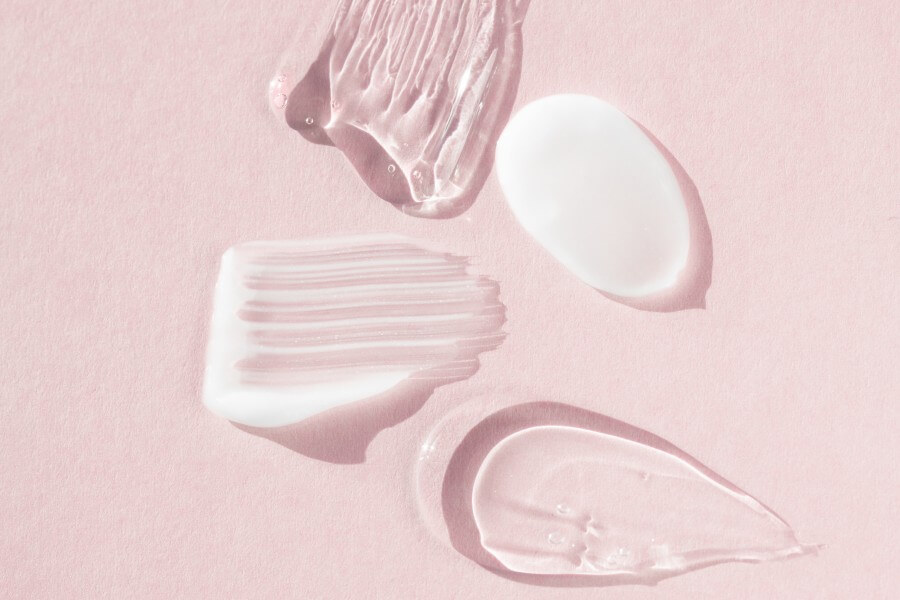 cream and hyaluron samples, smears on a pink background. dermatological and cosmetic product, macro.