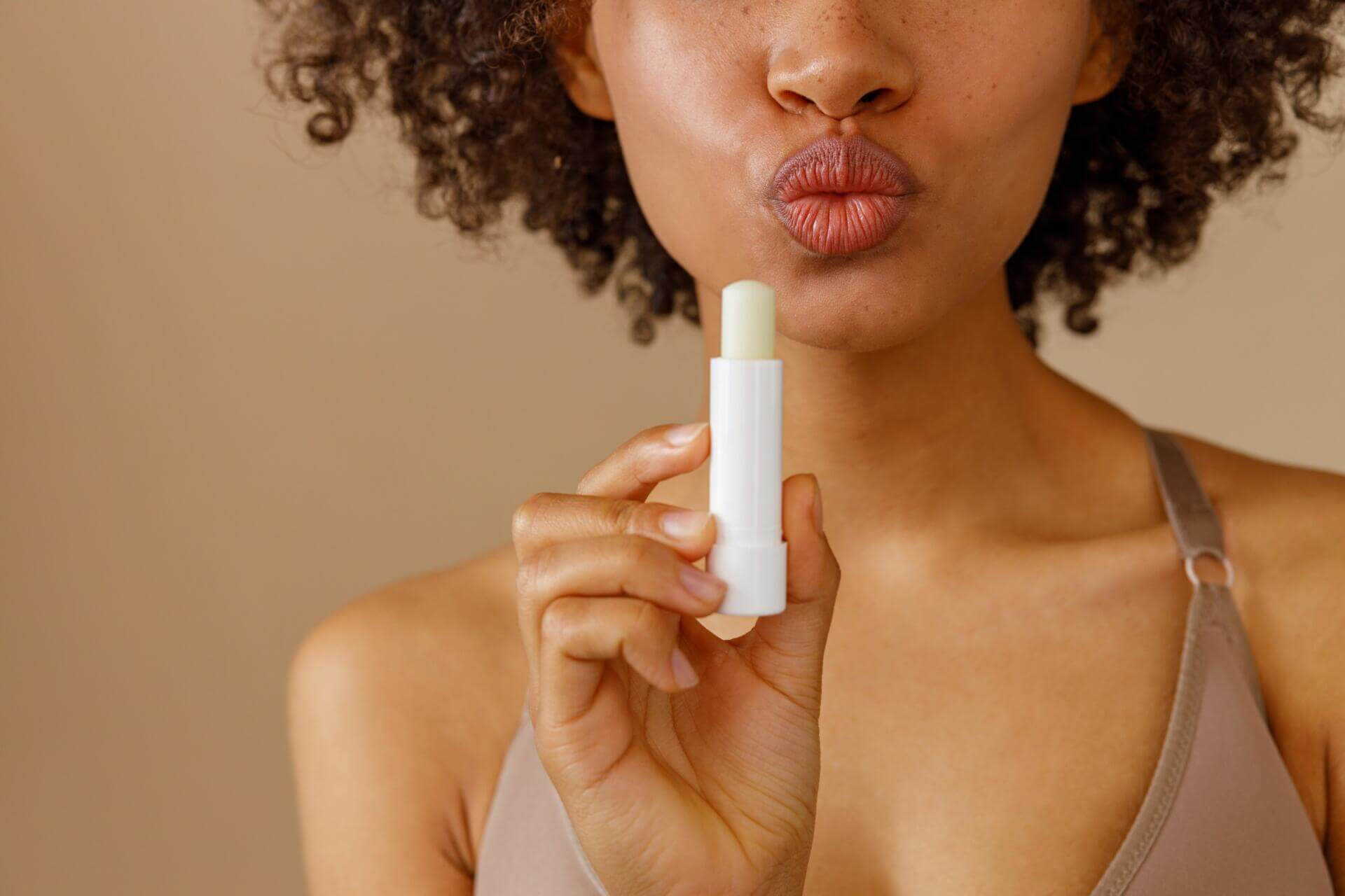 picture of beautiful woman with lip balm, indoors