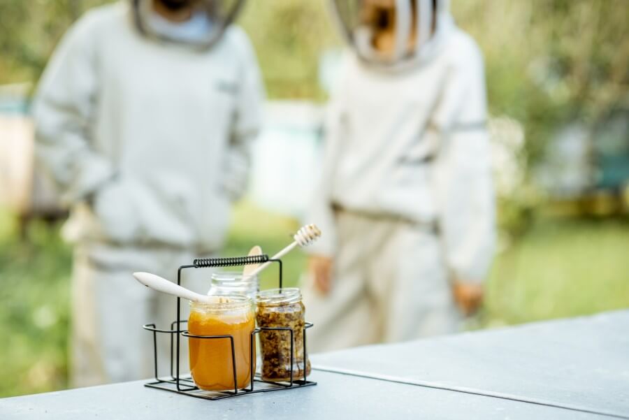 jars with fresh honey and beeswax on the apiary