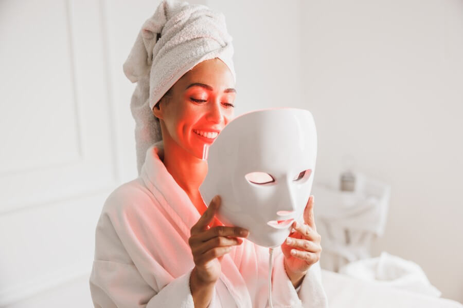 woman getting a led light facial mask treatment at the beauty salon