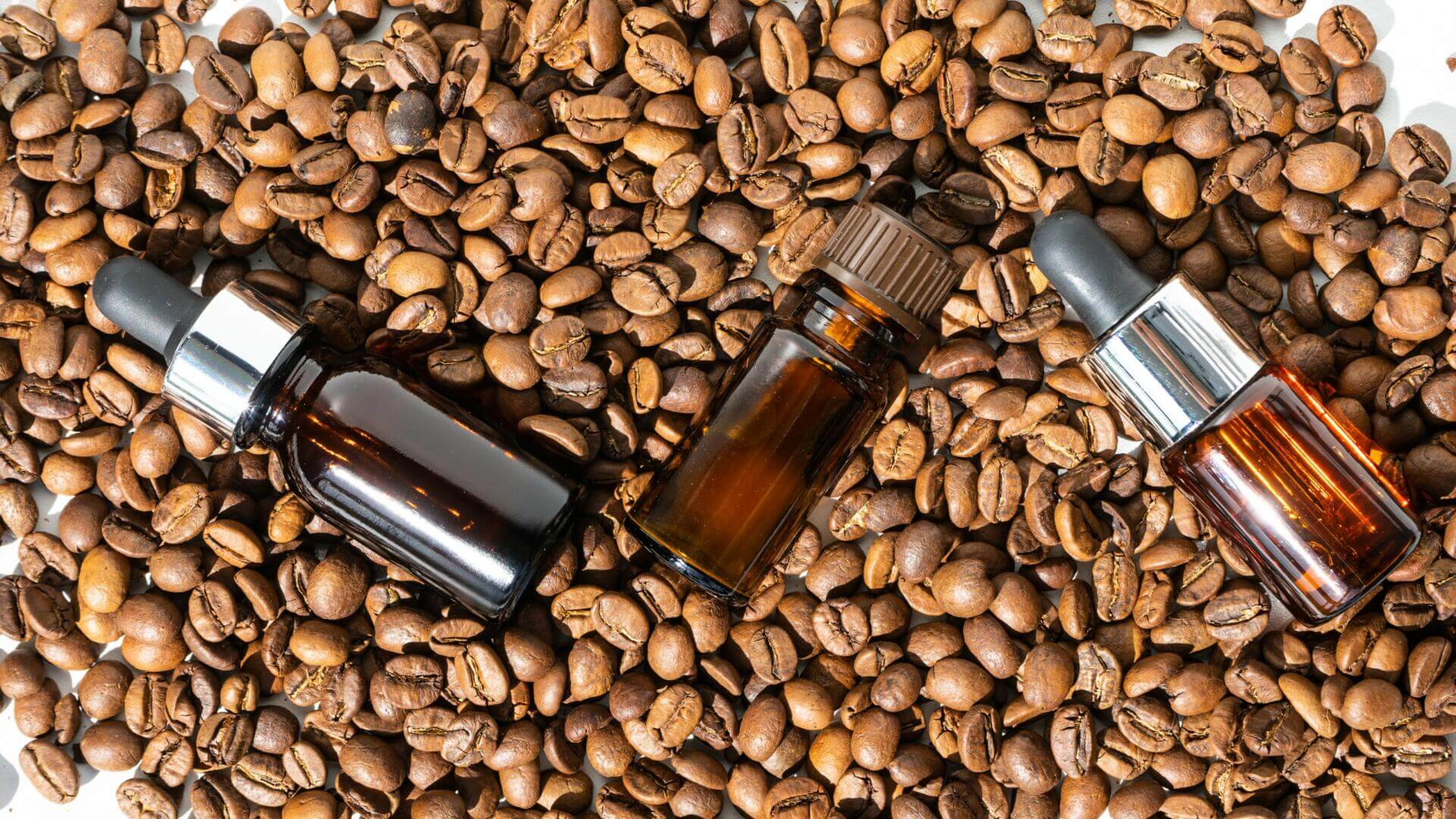 organic oil. cosmetic oil, facial and body skin care product with coffee extract. a glass bubble next to the coffee beans. coffee essential oil. selective focus.