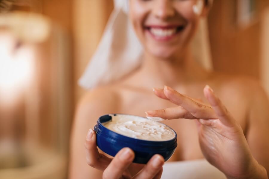 cloe up of woman using face cream in the bathroom.