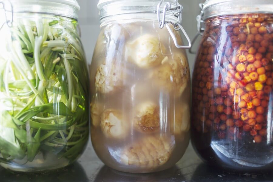 close up of pickle in jars at commercial kitchen