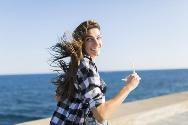 young pretty woman wearing beach wear wlaking by the sea