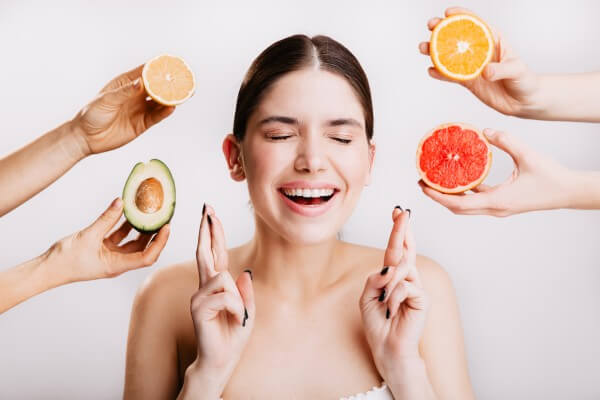 dark haired model with smile makes wish. young woman with clean skin is posing against background o