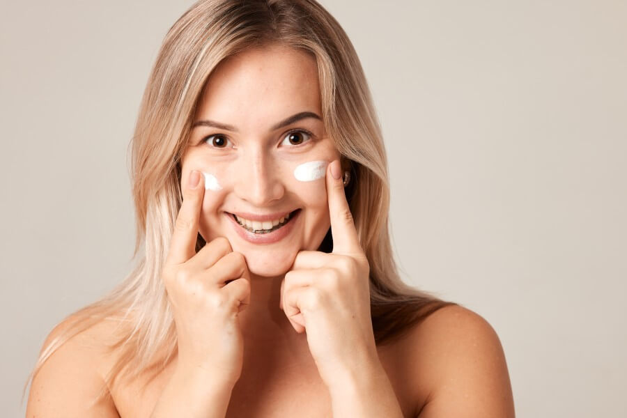 close up beauty portrait laughing beautiful half naked woman applying face cream make up health spa fresh skin