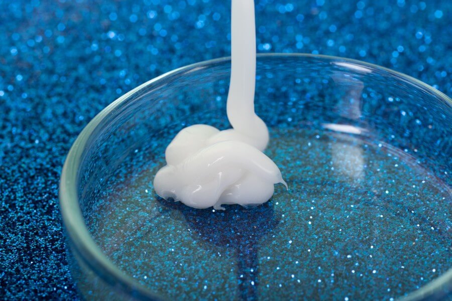 closeup photography of white cream dripping in petri dish.