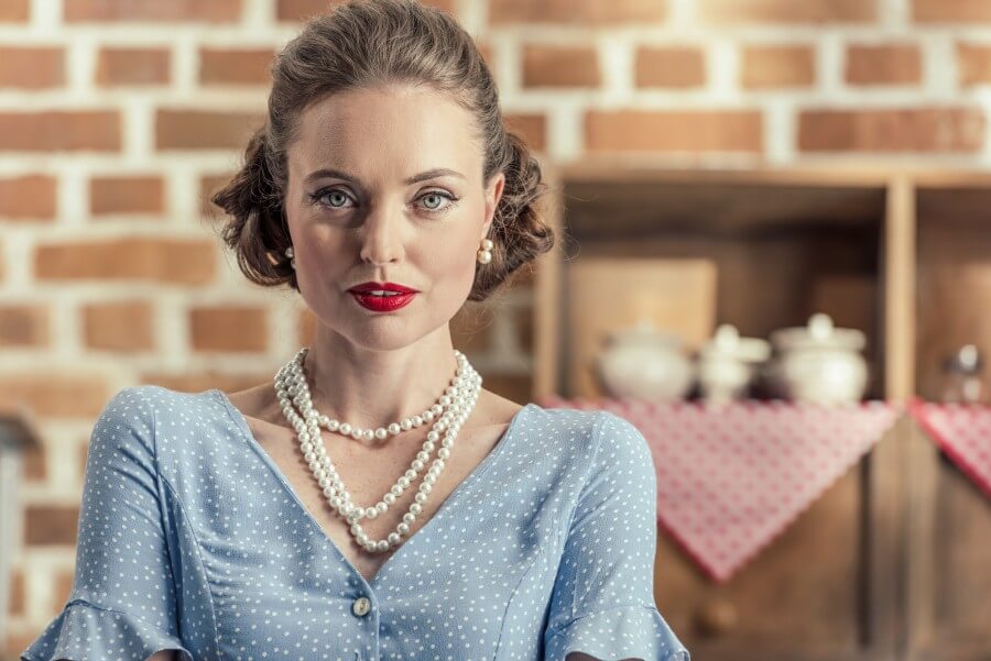 attractive adult housewife looking at camera at kitchen