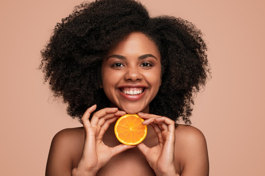 cheerful black woman with orange slice