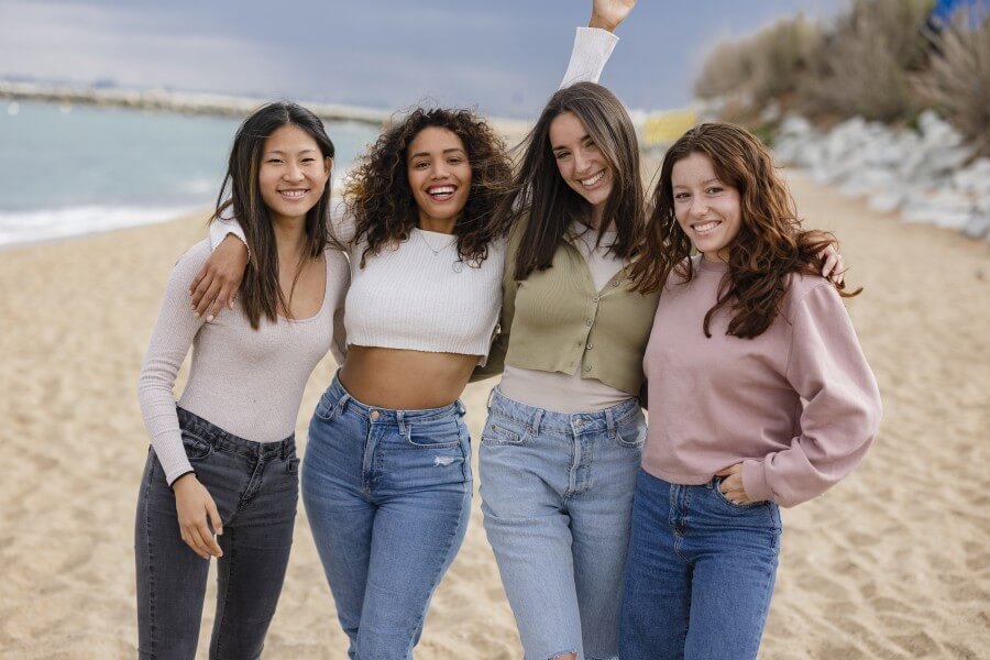 happy multiracial women on the beach partying