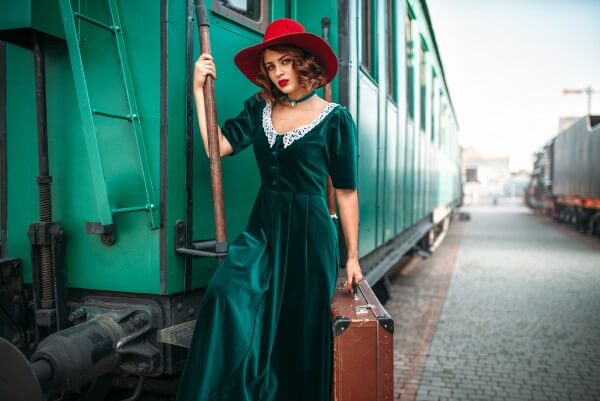 woman in red hat against old railway wagon