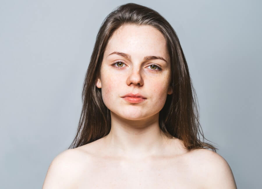 young beautiful woman freckles natural portrait. gray background