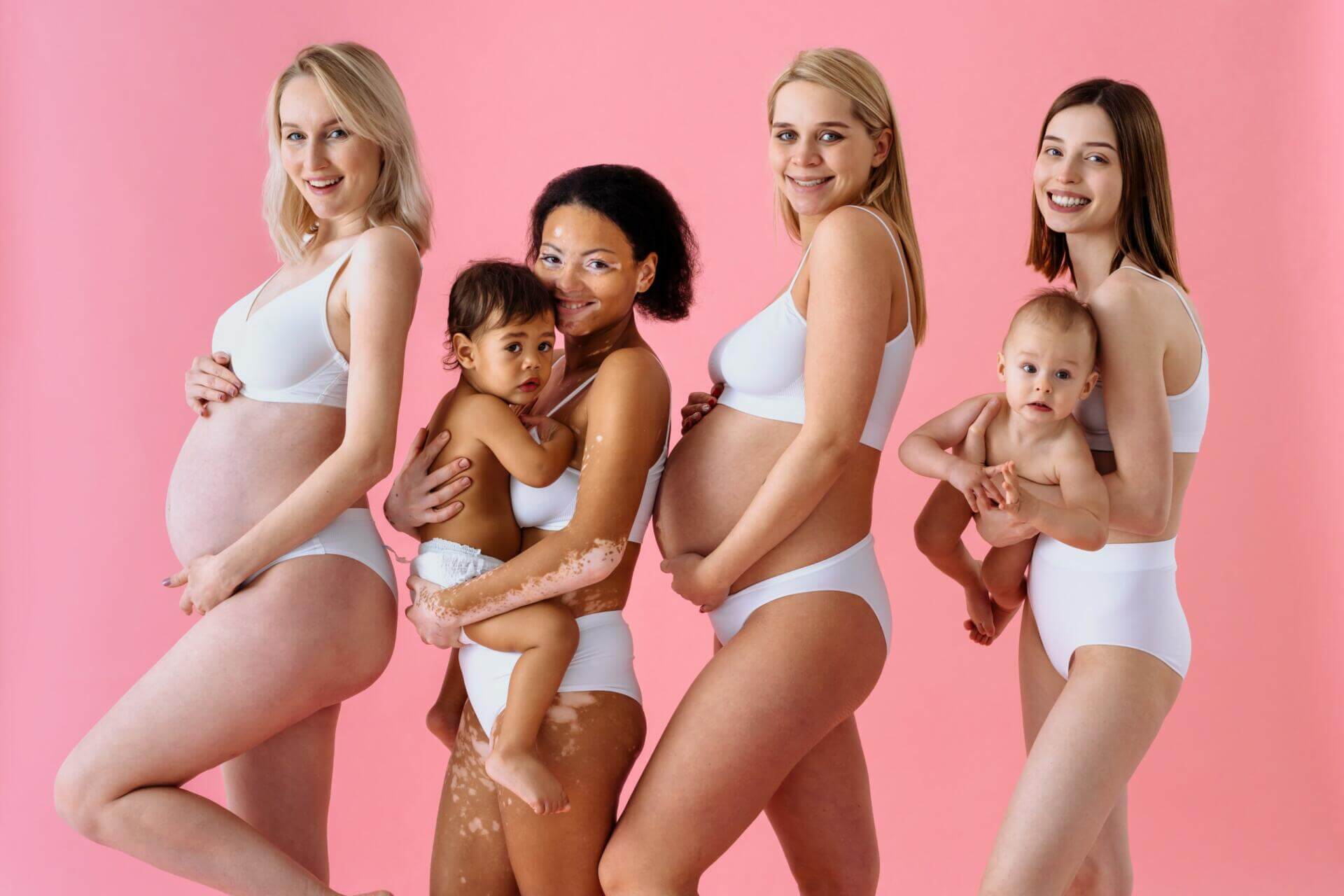 beauty shot of beautiful pregnant women and mothers holding babi