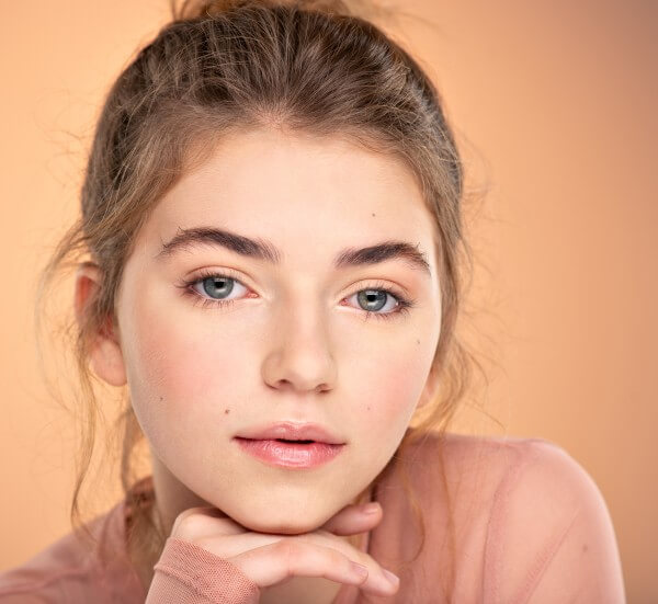 closeup portrait of an young girl over colored background. pho