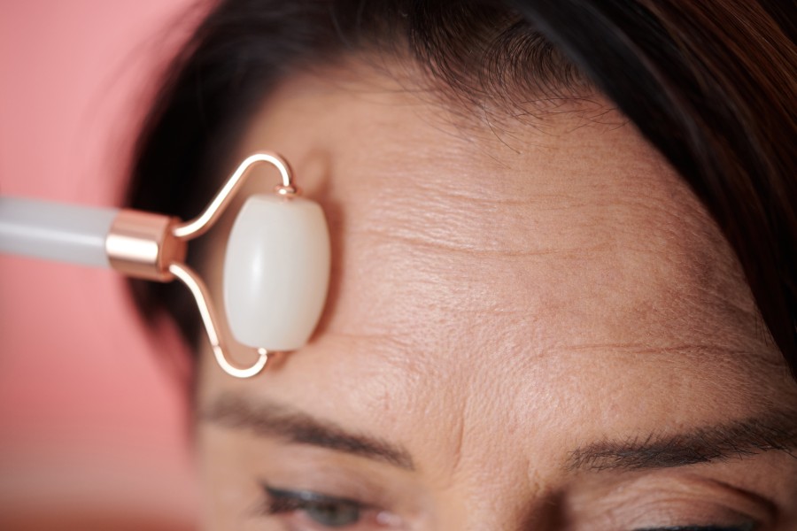 woman massaging forehead with roller