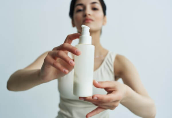 woman with a jar of lotion in her hands in a white t shirt skin care spa treatments